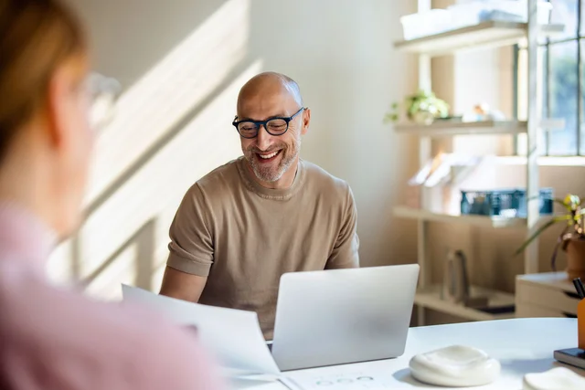 Mann am Schreibtisch vor Laptop
